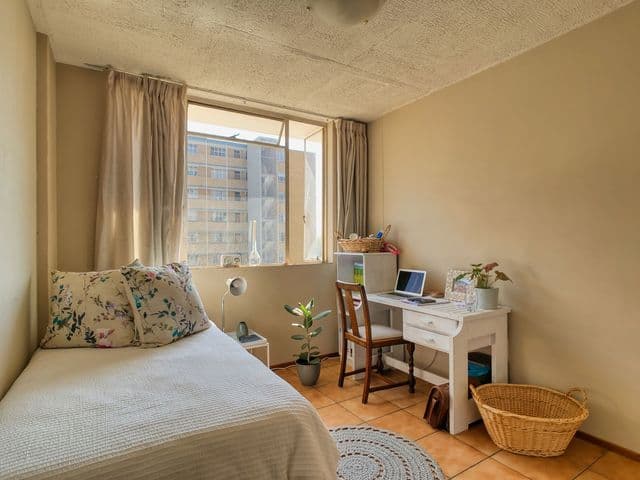Bright, tidy student bedroom with a desk and laptop, representing private rental accommodation for international students