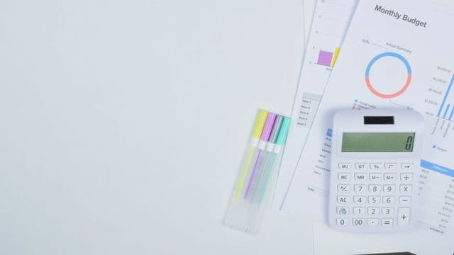 Calculator and budget planning documents on a desk, representing the cost of studying abroad