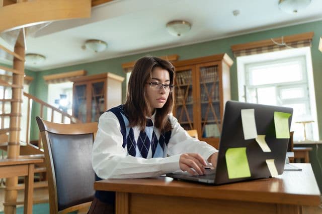 Student writing at a desk during a workshop