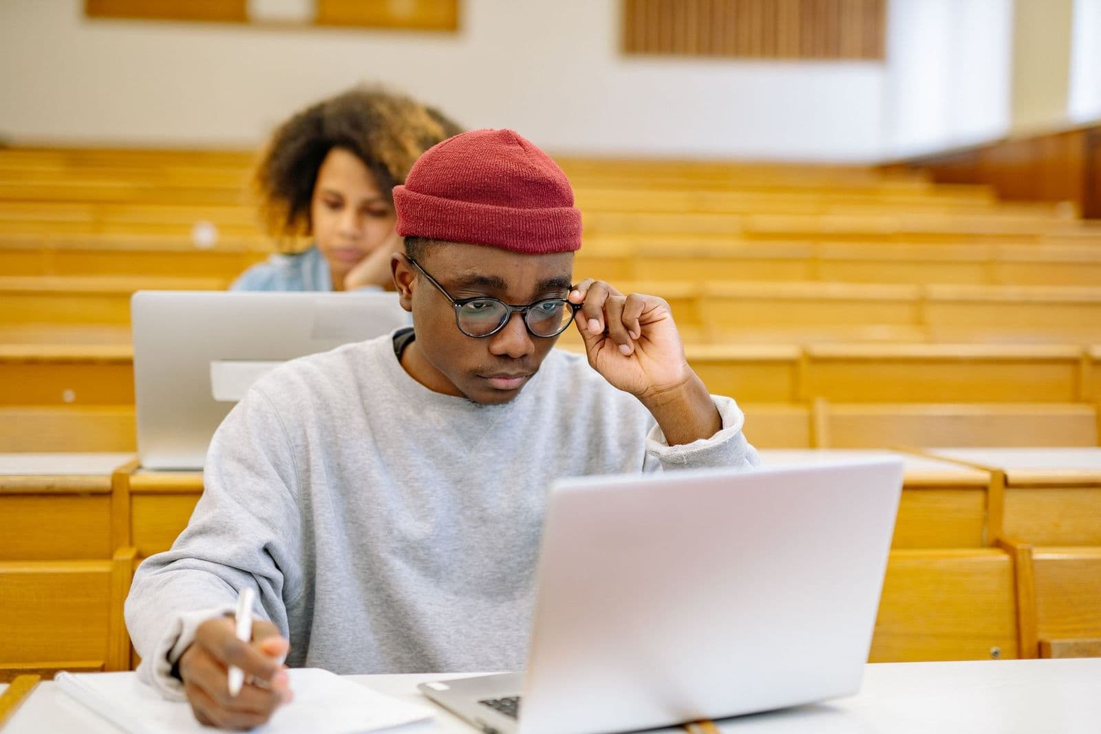 Students studying with laptops in a university lecture hall, preparing for exams such as IELTS