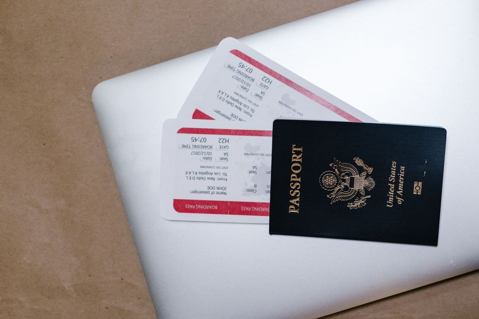 Passport and boarding pass placed on a laptop keyboard, representing UK student visa travel preparation